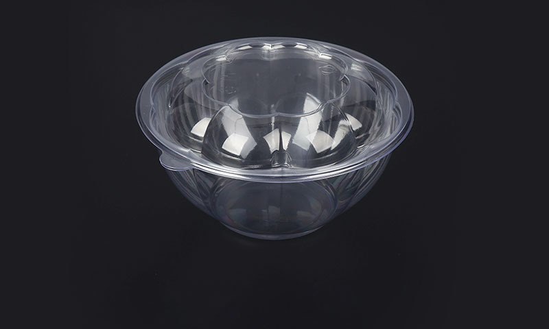 Clear PET salad bowl with domed lid on dark background